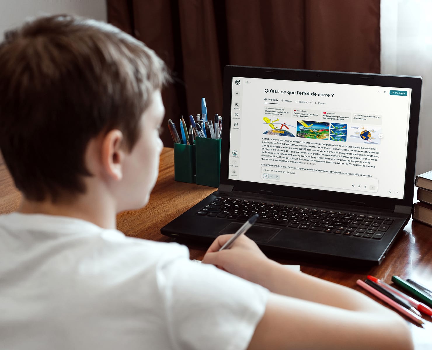 Étudiant à un bureau avec un ordinateur portable ouvert affichant une conversation de style Perplexity disant : Qu'est-ce que l'effet de serre ?